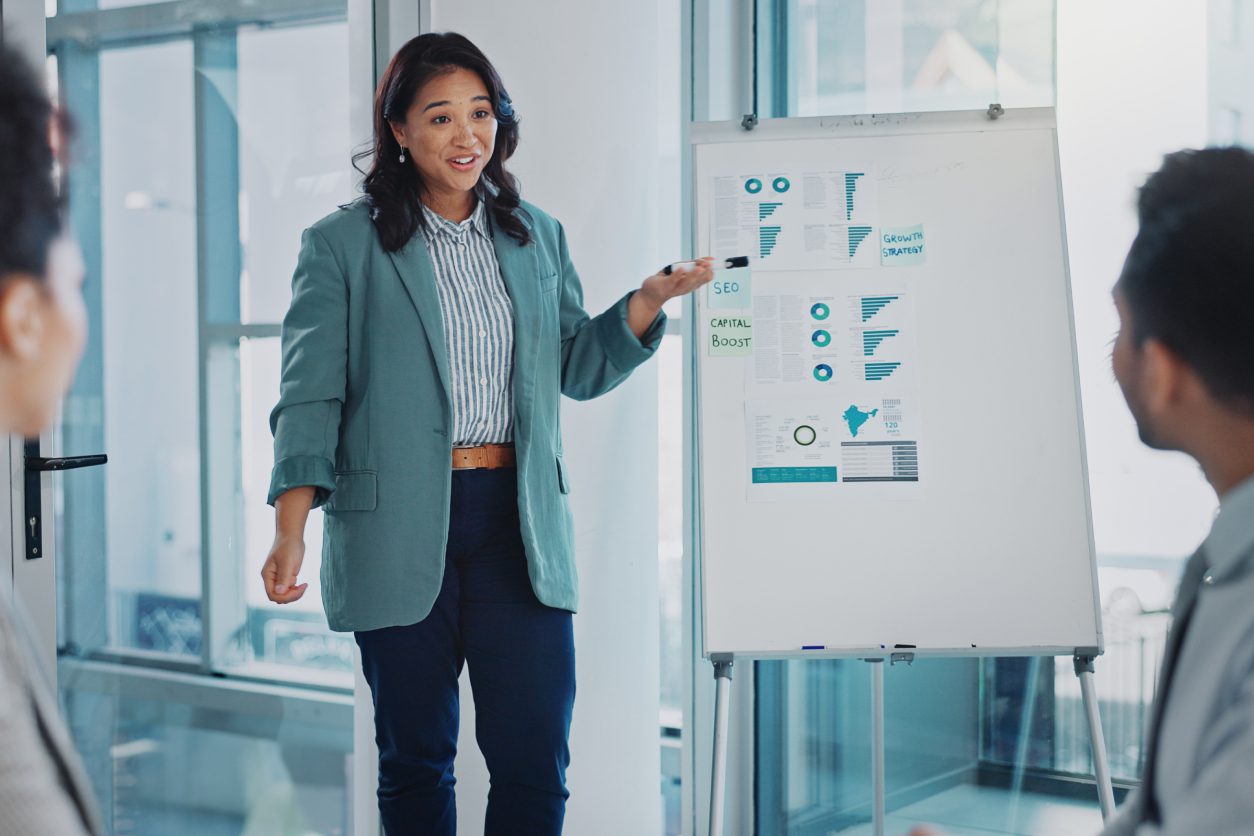 New Project (2) Woman presenting data on a flip chart.
